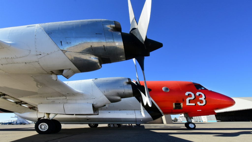 A P-3 airplane belonging to Airstrike Firefighters LLC stands on the runway.