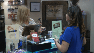 Monica Clayton checking ID before selling e-cigarette product.